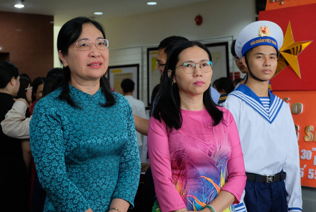 Đ/c Lê Thị Ngọc Điệp, Đ/c Lê Thị Trâm Anh (từ trái sang phải) nghe thuyết minh về các tư liệu tại triển lãm - Ảnh Huyền Linh